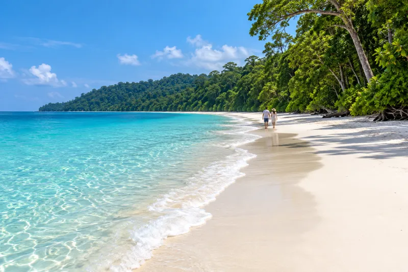 Couple walking along white sand at Radhanagar Beach