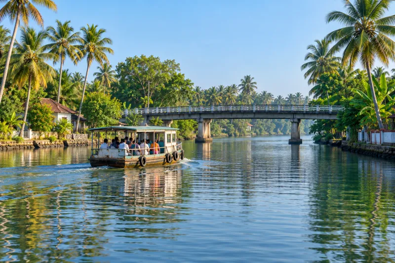 Public ferry crossing palm-lined Alappuzha canal near bridge
